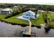 Aerial view of a waterfront house, pool, boat dock, and beautiful landscaping at 9061 Kellogg Ln, Venice, FL 34293