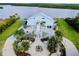 Elegant waterfront home featuring mature landscaping, circular drive, and covered parking at 9061 Kellogg Ln, Venice, FL 34293