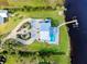 Stunning aerial view of a waterfront home with a private dock, pool, and lush landscaping at 9061 Kellogg Ln, Venice, FL 34293