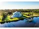 Aerial view of a waterfront home with a pool, dock, and lush landscaping at 9061 Kellogg Ln, Venice, FL 34293