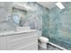 Elegant bathroom featuring blue marble tiling, a modern vanity, and glass-enclosed shower at 9061 Kellogg Ln, Venice, FL 34293