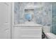 Stylish bathroom features blue onyx tile, vessel sink on marble top, and a modern, bright aesthetic at 9061 Kellogg Ln, Venice, FL 34293