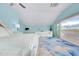 Bright bedroom offers a large bed, seating area, and a sliding glass door leading to a balcony at 9061 Kellogg Ln, Venice, FL 34293