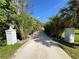 Long driveway lined with palms leading to a home with beautiful landscaping at 9061 Kellogg Ln, Venice, FL 34293