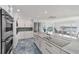 Gourmet kitchen boasts white cabinetry, stainless steel appliances, and a large center island with cooktop at 9061 Kellogg Ln, Venice, FL 34293