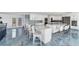 Bright kitchen featuring a large island with marble countertop, white cabinets and modern appliances at 9061 Kellogg Ln, Venice, FL 34293