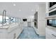 Bright white kitchen featuring stainless steel double ovens, white cabinetry, and blue and brown marble floors at 9061 Kellogg Ln, Venice, FL 34293