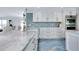 Kitchen with marble countertop and backsplash, custom cabinets, and premium stainless steel appliances at 9061 Kellogg Ln, Venice, FL 34293