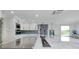 Modern kitchen featuring white cabinets, stainless appliances, a large island, and stylish backsplash at 9061 Kellogg Ln, Venice, FL 34293