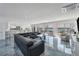 Expansive living room featuring a large sectional sofa, sleek marble floors and water views at 9061 Kellogg Ln, Venice, FL 34293