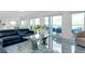 Bright living room with blue marble floors, sliding glass doors, and a unique glass coffee table at 9061 Kellogg Ln, Venice, FL 34293