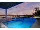 Night view of the glowing pool and manicured lawn at 9061 Kellogg Ln, Venice, FL 34293