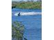 Waterfront view of a jet ski speeding across the blue water at 9061 Kellogg Ln, Venice, FL 34293