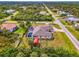Aerial view of a landscaped property featuring a large screened pool, a separate storage shed, and mature tropical foliage at 9407 Prospect Ave, Englewood, FL 34224