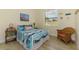 Bedroom features a twin bed, colorful accents, a woven chair, and a window providing natural light to the room at 9407 Prospect Ave, Englewood, FL 34224