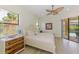 Bright bedroom boasts a ceiling fan, wood-look flooring, and sliding glass doors to the outdoor patio and pool at 9407 Prospect Ave, Englewood, FL 34224