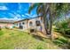 Exterior of home with mature landscaping, garden beds and screened-in porch with pool at 9407 Prospect Ave, Englewood, FL 34224