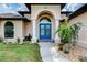Charming front entry with blue double doors, manicured landscaping, and stone walkway at 9407 Prospect Ave, Englewood, FL 34224
