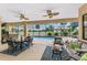 Relaxing screened-in patio with ceiling fans, dining area, and comfortable seating overlooking the pool at 9407 Prospect Ave, Englewood, FL 34224