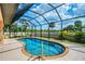 Sparkling screened-in pool with clear blue water and manicured landscaping at 9407 Prospect Ave, Englewood, FL 34224