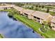 Aerial view of community overlooking a serene lake and lush landscaping at 410 Mission E Trl # H, Venice, FL 34285