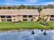 Waterfront aerial view of condo with palm trees and landscaping at 410 Mission E Trl # H, Venice, FL 34285