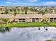 Aerial view of home with balcony overlooking a serene lake and lush landscaping at 410 Mission E Trl # H, Venice, FL 34285