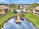 Aerial view of a community pool, dock, and pond surrounded by well-maintained lawns and tropical landscaping at 410 Mission E Trl # H, Venice, FL 34285