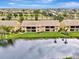 Aerial view of home overlooking a serene lake and lush landscaping at 410 Mission E Trl # H, Venice, FL 34285