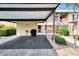 View of a condo carport featuring parking space and storage, with lush landscaping at 410 Mission E Trl # H, Venice, FL 34285