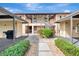 Exterior condo entrance with landscaped walkway, covered parking and second-floor access at 410 Mission E Trl # H, Venice, FL 34285