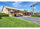 View of two-story condo building with covered parking and manicured landscaping at 410 Mission E Trl # H, Venice, FL 34285