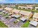 Aerial view of a well-maintained two-story condo community with carports, ponds, and mature landscaping at 410 Mission E Trl # H, Venice, FL 34285