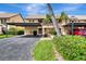 View of two-story condo with covered parking and manicured landscaping at 410 Mission E Trl # H, Venice, FL 34285