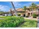 View of two-story condo with covered parking and well-maintained landscaping at 410 Mission E Trl # H, Venice, FL 34285