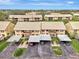 Aerial view of a two-story condo community with carports and well-maintained landscaping at 410 Mission E Trl # H, Venice, FL 34285