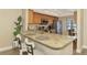 Well-equipped kitchen with granite counters, modern appliances, and a cozy breakfast bar at 410 Mission E Trl # H, Venice, FL 34285