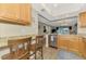 Modern kitchen featuring granite countertops, stainless steel appliances, wood cabinets and bar seating at 410 Mission E Trl # H, Venice, FL 34285