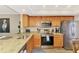 Functional kitchen space featuring granite countertops, stainless steel appliances, and wood cabinets at 410 Mission E Trl # H, Venice, FL 34285