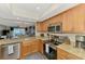 Modern kitchen featuring granite countertops, stainless steel appliances, and wood cabinets at 410 Mission E Trl # H, Venice, FL 34285