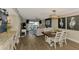 Open concept living room with dining area, contemporary decor, and sliding door access to a balcony at 410 Mission E Trl # H, Venice, FL 34285
