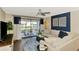 Stylish living room featuring a ceiling fan, balcony access, and eye-catching modern decor at 410 Mission E Trl # H, Venice, FL 34285