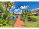 Scenic view from the dock of a tranquil pond with lush green lawns and well-maintained community buildings at 410 Mission E Trl # H, Venice, FL 34285