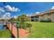 View from the dock of a tranquil pond surrounded by lush green lawns and well-maintained community buildings at 410 Mission E Trl # H, Venice, FL 34285