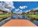 Scenic view from the dock of a tranquil pond surrounded by lush green lawns and well-maintained community buildings at 410 Mission E Trl # H, Venice, FL 34285