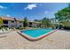 Outdoor pool with brick pavers and lounge chairs, with a view of the community buildings at 410 Mission E Trl # H, Venice, FL 34285