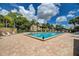 Outdoor pool with brick pavers and lounge chairs, with a view of the tropical landscaping at 410 Mission E Trl # H, Venice, FL 34285