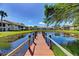 Scenic water view from wooden dock and tranquil pond with surrounding lush greenery at 410 Mission E Trl # H, Venice, FL 34285