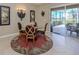 Dining room with a glass table, decorative rug and sliding glass doors leading to the screened patio at 2198 Chenille Ct, Venice, FL 34292