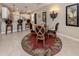 The dining room features a glass table, decorative rug, and bar-style seating to the kitchen at 2198 Chenille Ct, Venice, FL 34292